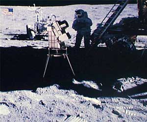 Фото NASA AS16-114-18439. Камера для съемок неба в ультафиолетовых лучах.
На заднем плане — астронавт Чарльз Дьюк, Ровер и флаг